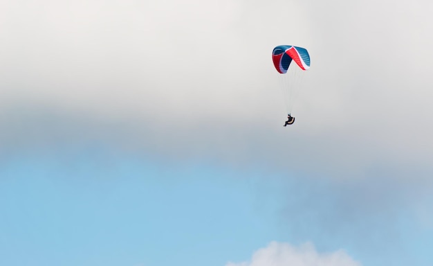 Planeur bleu et rouge un jour nuageux