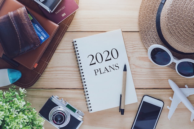 Plans de carnet de notes 2020 avec chapeau, lunettes de soleil, téléphone, appareil photo et avion