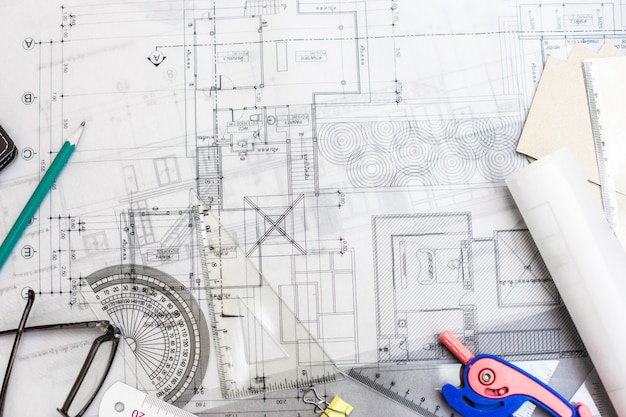 Plans de planification de la construction sur la table avec des crayons, une règle et des lunettes sur la table, effet rétro