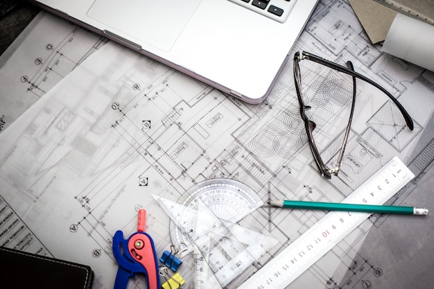 Plans de planification de la construction sur la table avec des crayons, une règle et des lunettes sur la table, effet rétro