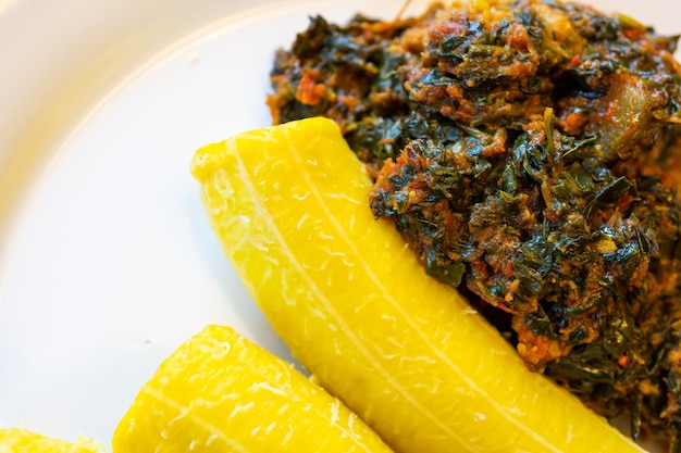 Plantain mûr bouilli nigérian servi avec une soupe de légumes