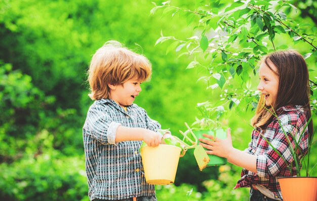 Planter des fleurs en pot sur l'enfance de campagne petit garçon et fille jardinage et avoir fu