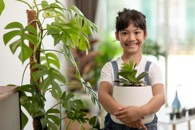 Plantes en pot à la maison tenues par un enfant mignon