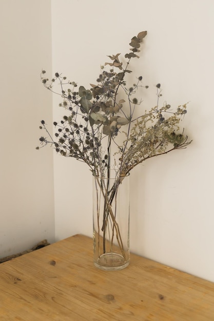 Plantes sèches dans un bocal en verre minimaliste Image verticale d'une branche avec des feuilles sèches dans un vase en verre simple et élégant Décoration et design d'intérieur