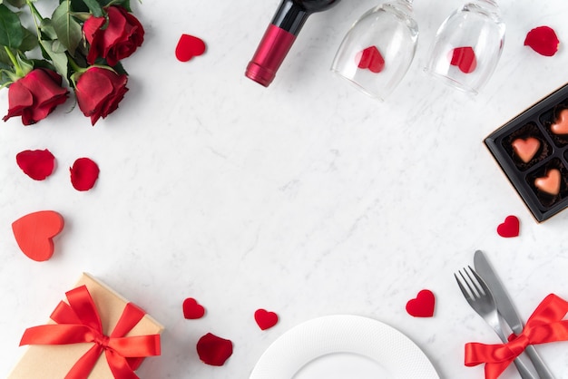 Plaque blanche avec fleur rose rouge sur fond de table en marbre blanc pour la Saint-Valentin datant concept de repas de vacances.