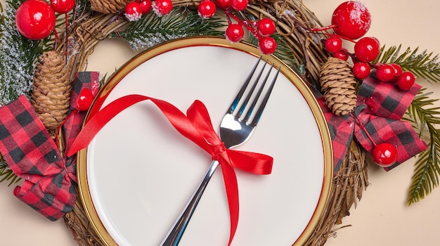 Plaque blanche ronde vide avec fourchette et cadeaux emballés avec décor de Noël