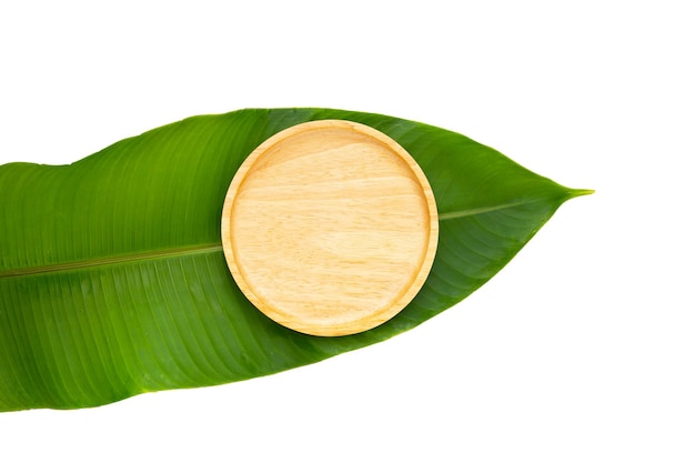 Plaque en bois sur des feuilles vertes sur fond blanc