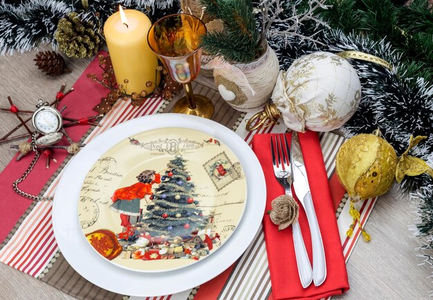 Plaque couteau fourchette verre et une variété de décorations de Noël sur un gros plan de table