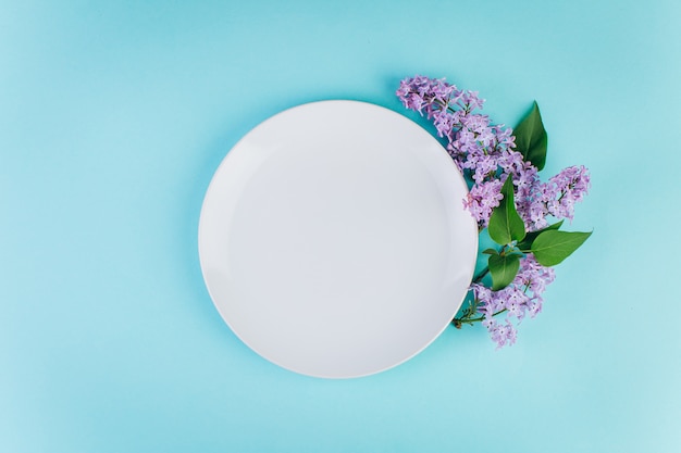 Une plaque avec un espace copie autour de violet lilas sur un fond bleu