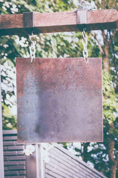 plaque de métal rouillé blanc accroché sur la barre de bois