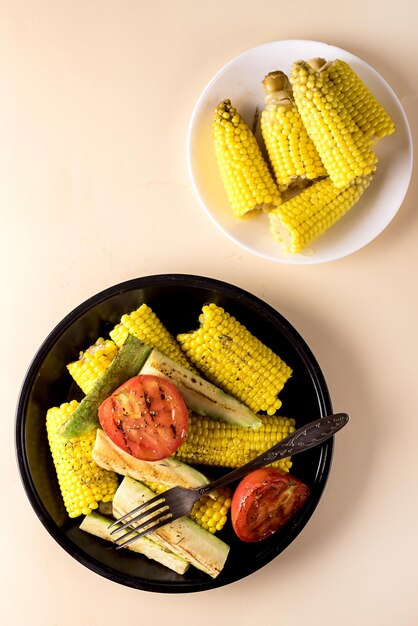 Plaque noire de légumes grillés Courgettes CornTomato Alimentation saine et savoureuse sur fond jaune