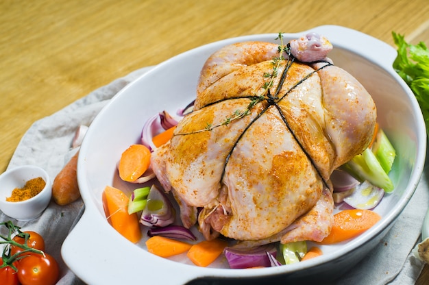 Une plaque à pâtisserie avec un morceau de poulet cru dans les épices.