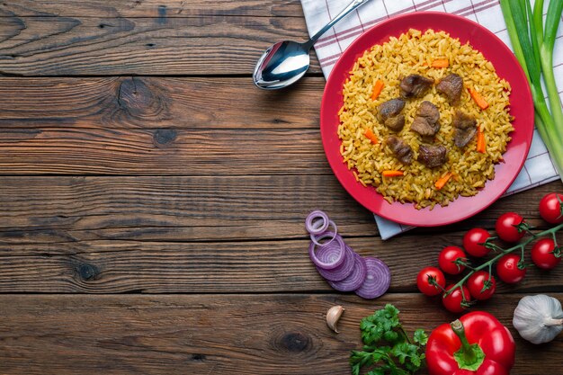 Plaque rouge avec pilaf sur un fond de table en bois blanc avec copysapce. Vue de dessus