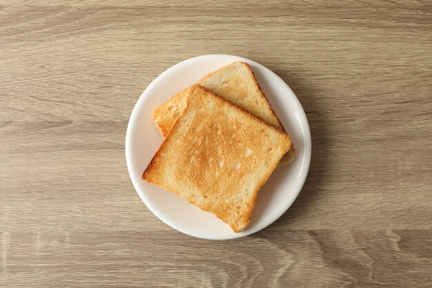 Plaque avec toasts sur fond en bois, vue de dessus