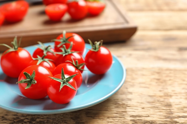 Plaque avec des tomates cerises fraîches en gros plan sur la table