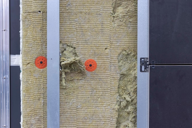 Plaques de technologie d'économie d'énergie en laine minérale sur la paroi latérale entre les profilés métalliques pour la fixation de la façade ventilée