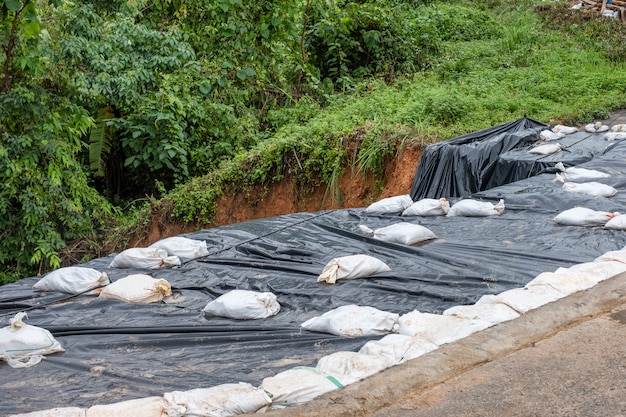 Plastique noir avec sac de sable recouvert sur une route effondrée