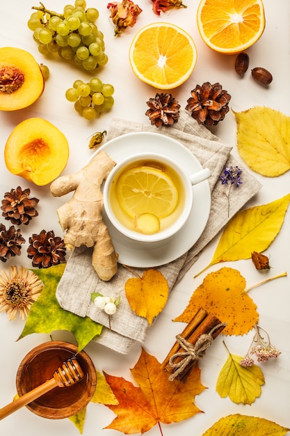 Plat d&#39;automne: thé, fruits d&#39;automne et décorations sur fond blanc.