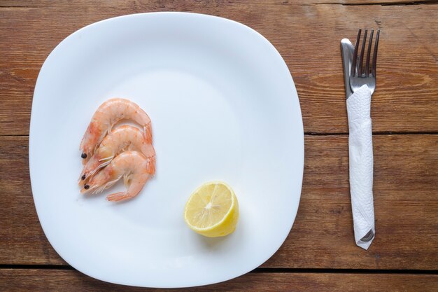 Plat blanc servi avec crevettes et citron