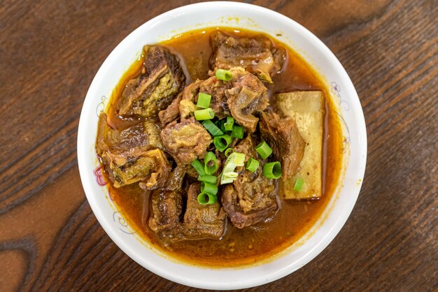 Le plat de boeuf est dans l'assiette sur la table en bois