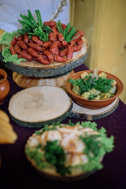 Plat en bois avec des collations et de la viande se trouve sur la boîte sur la table du dîner