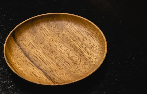 Le plat en bois sur la table noire