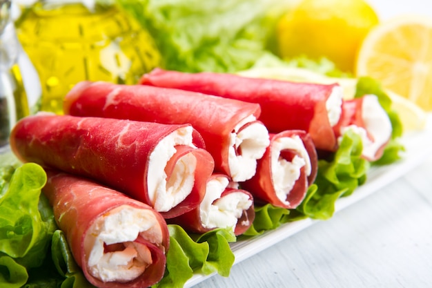 plat avec bresaola et rouleaux de fromage avec salade