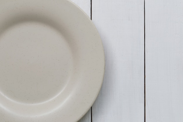 Le plat de carrelage est placé sur un plancher en bois blanc.