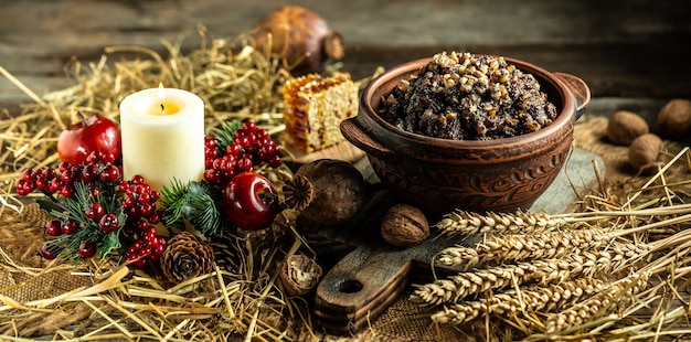 Plat de céréales de Noël traditionnel ukrainien avec du miel, des raisins secs et des graines de pavot