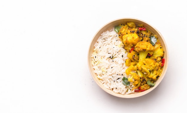 Plat de chou-fleur Gobi aloo avec du riz dans un bol sur blanc