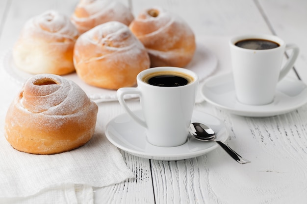 Un plat de crème choux avec une tasse de thé ou de café pour une pause après-midi.