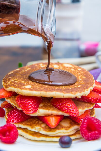 Plat avec crêpes et fraise, framboise et myrtille et chocolat