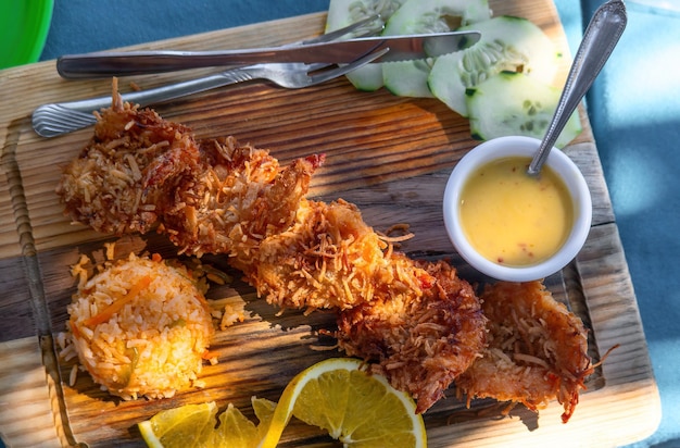 Plat de crevettes à la noix de coco avec riz à l'orange et sauce épicée