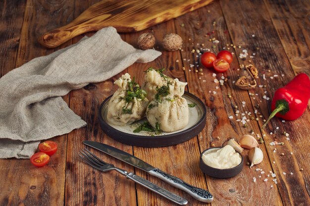 Plat de cuisine géorgienne khinkali dans une belle assiette sur table en bois