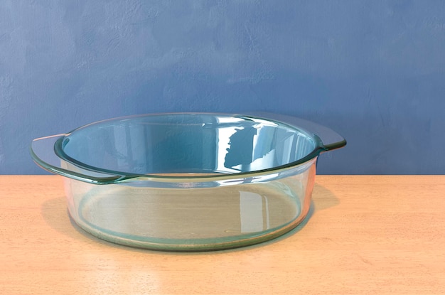 Plat de cuisson rond en verre transparent sur la table en bois rendu 3D