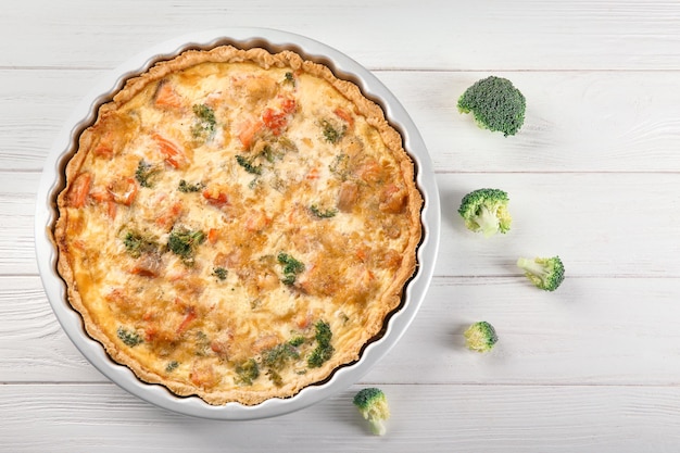 Plat de cuisson avec une savoureuse quiche au brocoli sur table