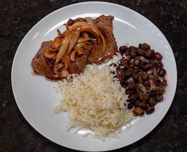Le plat de déjeuner brésilien le plus traditionnel est le steak de haricots noirs, de riz et d'oignon.