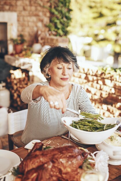 Plat de dîner et femme âgée avec de la nourriture lors d'un dîner en plein air ou d'un événement dans le jardin Déjeuner et dame âgée servant des légumes avec de la viande rôtie à une table à manger à l'extérieur chez elle