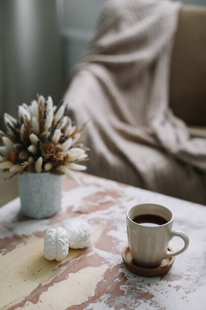 plat élégant avec une tasse de café avec des guimauves et des fleurs