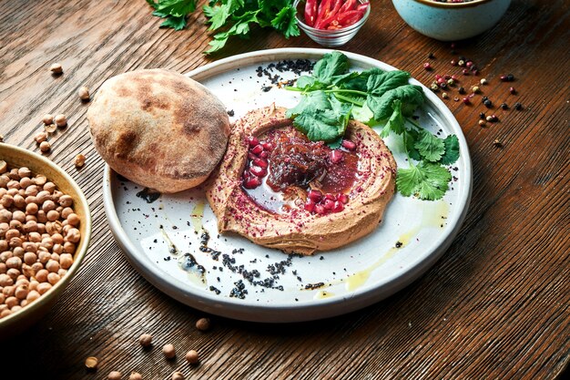 Plat français appétissant - pâté de poulet avec confiture d'oignon et pain pita servi dans une assiette blanche sur une table en bois. Vue rapprochée