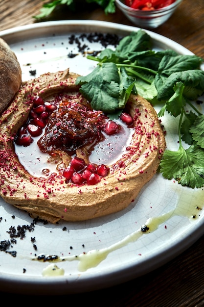 Plat français appétissant - pâté de poulet avec confiture d'oignon et pain pita servi dans une assiette blanche sur une table en bois. Vue rapprochée