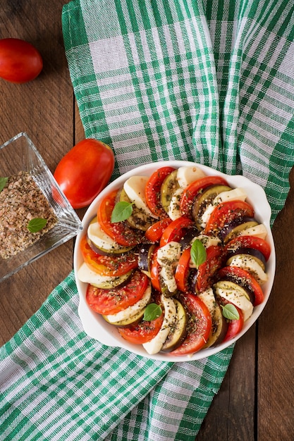 Plat gratiné d'aubergines crues avec mozzarella et tomates