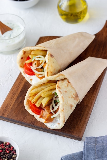 Plat grec gyros avec poulet, frites, tomates, oignons et pita. Cuisine grecque.