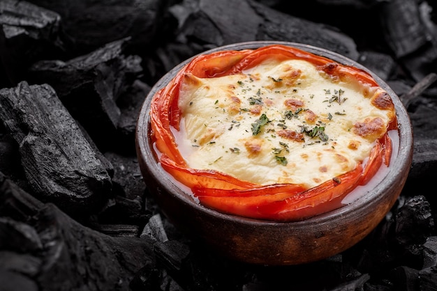 Plat grillé traditionnel avec du fromage, des légumes verts et du poivre