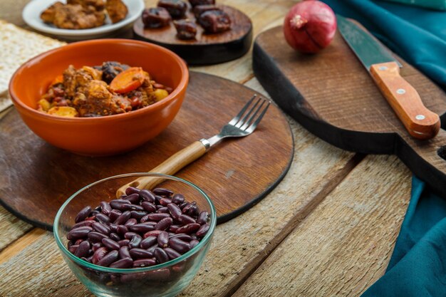 Plat juif chelnt avec de la viande dans une assiette sur une table en bois sur un support à côté des ingrédients. photo horizontale