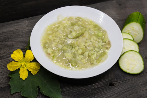 Plat de luffa à l'ail et à l'oignon sur fond de bois