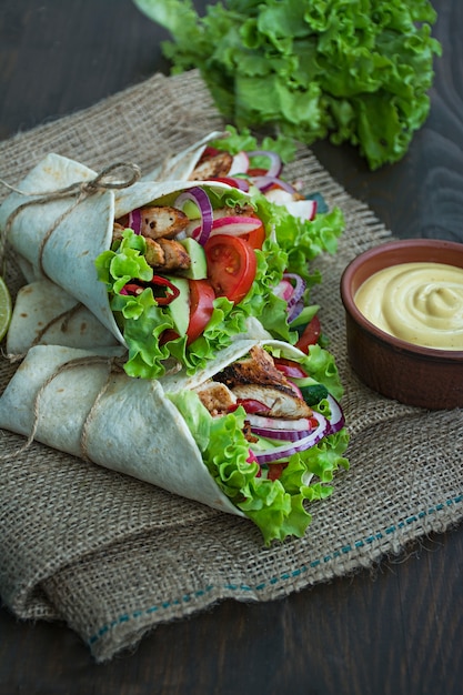 Plat mexicain. Taco avec gros plan de poulet et de légumes sur une surface en bois.