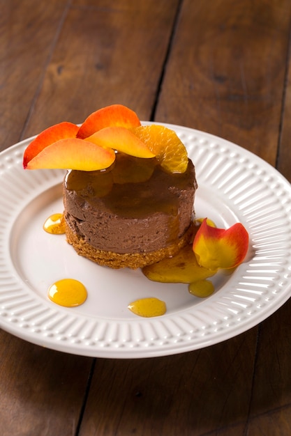 Un plat de mousse au chocolat avec du sirop de mandarine sur la table.