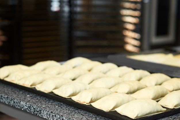 Plat noir avec une pâte crue roule sur la table