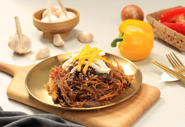 Photo plat de nouilles chapchae en verre de la cuisine coréenne japchae avec des légumes et de la viande. cuisine traditionnelle asiatique, repas coréen authentique.